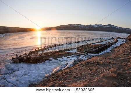 At Dawn Skeleton Of A Ship Frozen In The Ice On The Shore