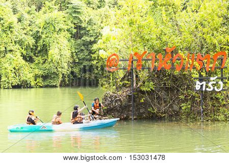 Koaw-Hua-Tag,October-20-2016,Travelers with a canoe and flag of Koaw-Hua-Tag,Trang province of Southern Thailand.01