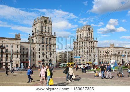 Minsk, Belarus - August 17, 2016: Two towers on Railway station square City Gates. Pedestrians (people, women, men) : tourists and residents go and walk down the street. Sunny summer day.