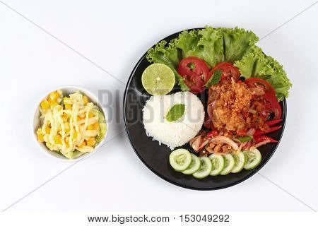 Home made,Jasmine rice with spicy fried chicken salad (Khao Yum Kai Zap in Thai) topped sliced cucumber,tomato,halved lemon and lettuce served with mixed vegetables salad.