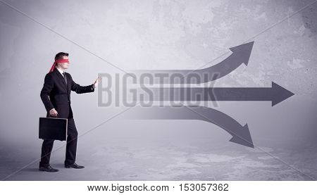 An amateur young sales person lost in a new situation concept with blindfolded businessman surrounded by drawn question marks.