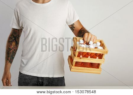 Man In Unlabeled White T-shirt With Box Of Orange Drinks
