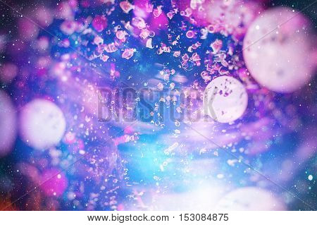 Festive background with natural bokeh and bright purple lights. Vintage Magic background with colorful bokeh. Spring Summer Christmas New Year disco party background.