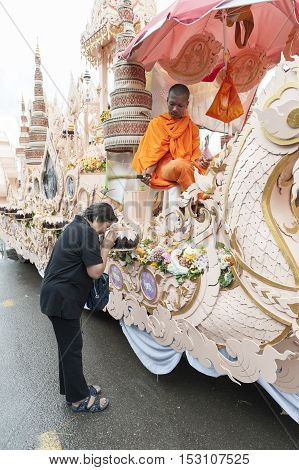 Suratthani, Thailand - October 20, 2016: Buddhist monk sitting on ornamented carriers to be pulled across the city during the famous Chak Phra Festival, an annual Buddhist festival to celebrate the return of Buddha from heaven to earth after the end of th