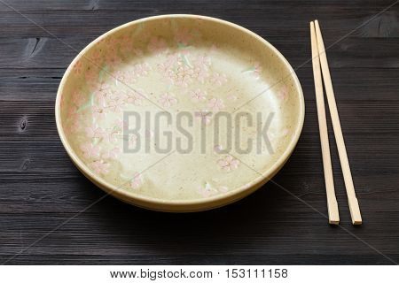 Yellow Green Plate And Chopsticks On Dark Brown
