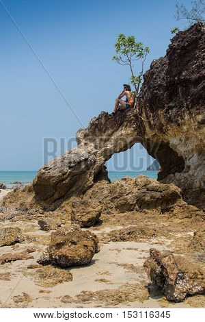 Sexy male vagabond beach bum taking a nap on a rock.