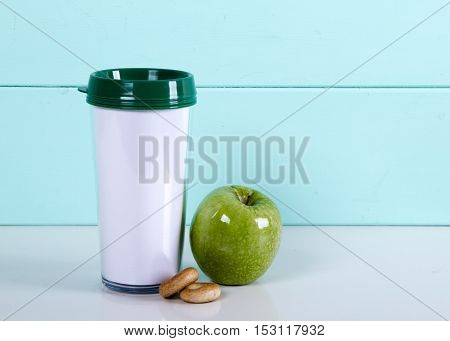 Thermocup apple bagels on a wooden blue background on the table. autumn tea