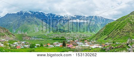 The mountain resort of Stepantsminda (former Kazbegi) located in the mountain valley and surrounded by the huge mountains of Higher Caucasus Range Georgia.