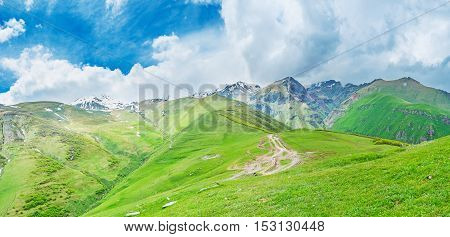 The green hills and mountain slopes of Kazbegi National Park at the foot of Kazbek Mount covered with clouds Gergeti Georgia.