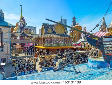MOSCOW RUSSIA - MAY 10 2015: The replica of the wooden ship on sea made of blue timbers with the mansions and izba houses of Izmailovsky market-town on the background on May 10 in Moscow.
