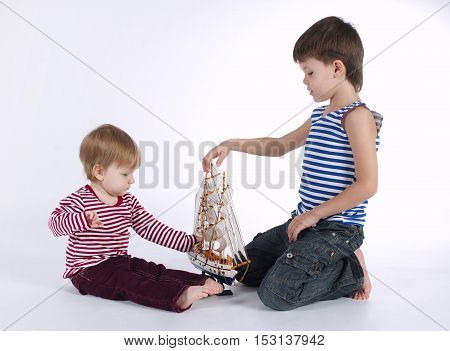 boy and girl playing with ship on white