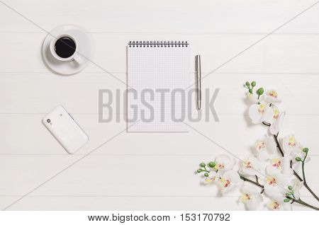 Feminine, elegant woman's white, wooden table, desk or workspace seen from above. Top view background with copy space. Creative workspace for freelance girl working from home