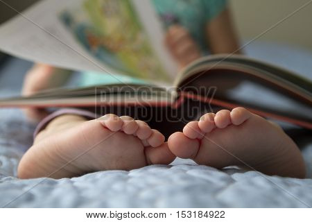 Foot closeup. An image of a toddler reading a book at home