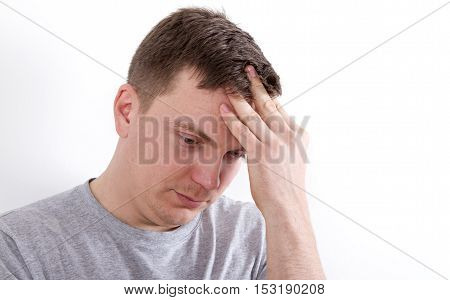 man holding his head portrait of a thought. gray T-shirt white background