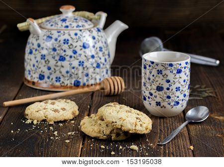 Morning tea with sweet biscuits and teapot behind.