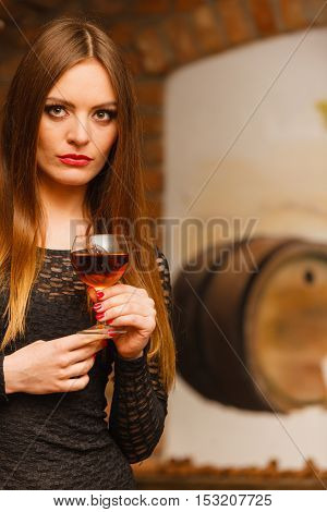 Woman Tasting Wine In Rural Cottage Interior