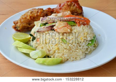 fried rice with mixed seafood and crispy chicken on plate