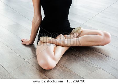 Closeup of crossed legs of young gaceful woman ballerina in ballet studio