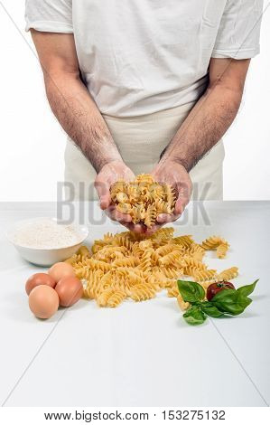 Cook in white coats preparing the sauce for Italian pasta.