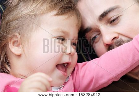 cheerful little girl and daddy having fun laughting very emotional