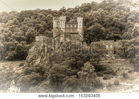 Rheinstein castle on the Rhine River Germany. Black and white photography sepia toned.
