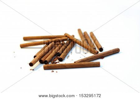 cigarillos and cigars chaotic stack on white background
