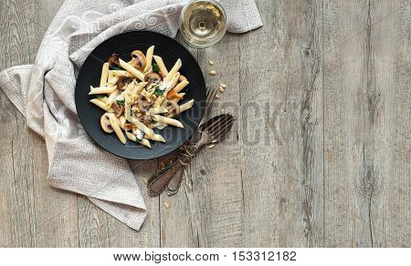 Pasta with mushrooms on rustic wooden table with a space for your text