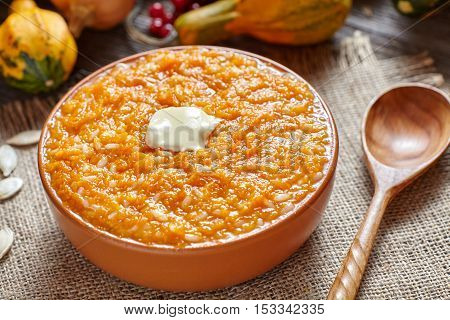 Vegan pumpkin rice porridge pudding breakfast homemade sweet baked dessert healthy organic diet food with butter traditional autumn meal on vintage table background