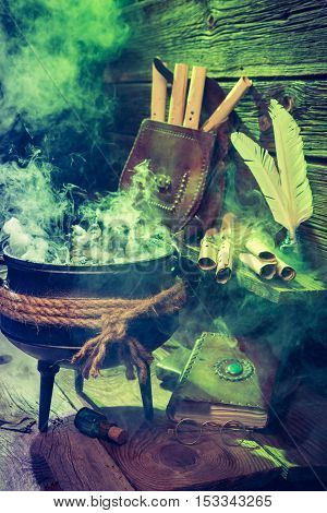 Old Witcher Cauldron With Green Smoke And Books For Halloween