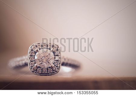 Closeup of diamond engagement ring on soft background.
