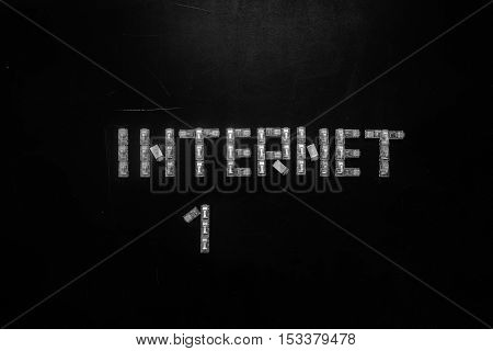 Word "Internet" and numeral "1" made of connectors RJ45 for LAN isolated over the black scratched board background.