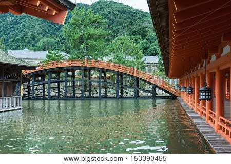 Hiroshima Japan - September 20 2016: Bridge and vermilion halls at itsukushima Shinto Shrine on Miyajima Island. Row of lanterns. Construction barely above sea level.