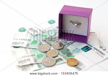 Ring in gift wrapping standing on thousandths of bills and coins