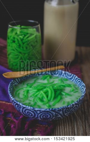 Lod Chong, Thai Dessert on Thai Textile with Wood Background Rice Noodles Made of Rice Eaten with Coconut Cream