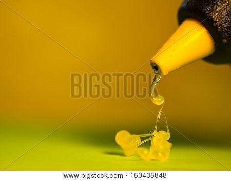 Hot glue gun tool with some heated glue leaking out.