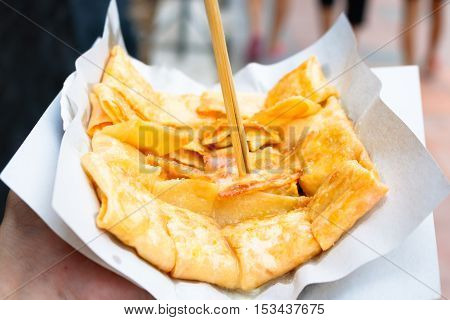 Man holding Indain Roti Parata with sweet.
