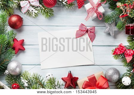 Christmas background with fir tree and decor on wooden table. Top view with blank greeting card for copy space. Gift wrappin