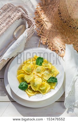 Tasty ravioli with spinach and ricotta on old wooden table