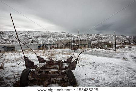 The old wooden houses and the remains of rusty cars Arctic Barents Sea the village of Teriberka