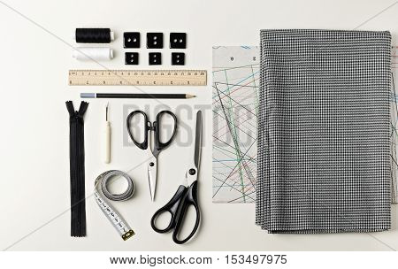 Everything for sewing in black and white. Fabric and thread zipper and buttons scissors and centimeter pencil and ruler.