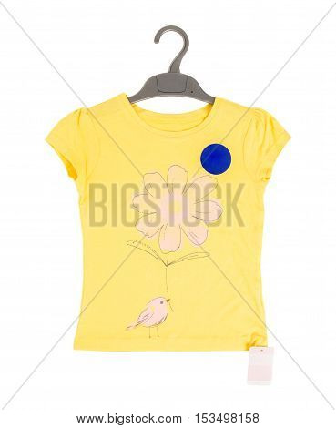 Yellow cotton t-shirt with flower and bird on black plastic hanger. Isolated on a white background.