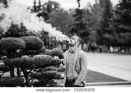 Men With Beard Smoking Electronic Cigarette Outdoor