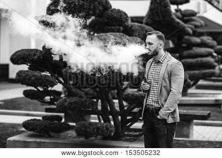 Men With Beard Smoking Electronic Cigarette Outdoor