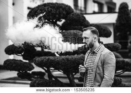 Men With Beard Smoking Electronic Cigarette Outdoor