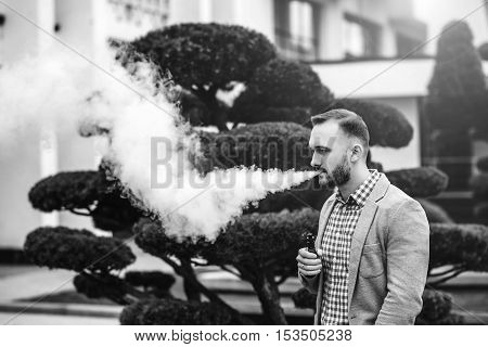 Men With Beard Smoking Electronic Cigarette Outdoor