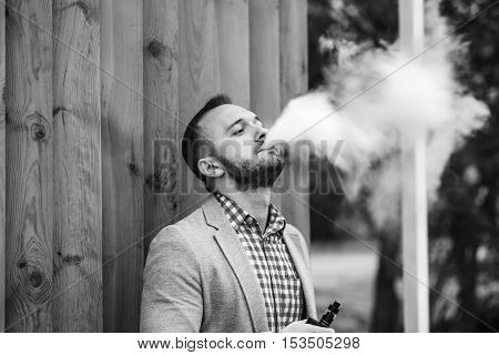 Men With Beard Smoking Electronic Cigarette Outdoor