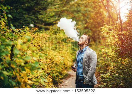 Men With Beard Smoking Electronic Cigarette Outdoor