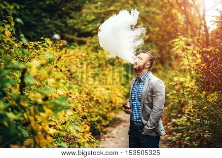 Men With Beard Smoking Electronic Cigarette Outdoor