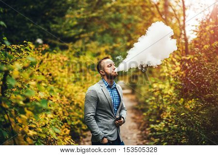 Men With Beard Smoking Electronic Cigarette Outdoor