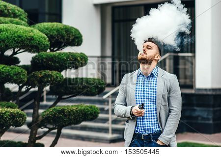 Men With Beard Smoking Electronic Cigarette Outdoor